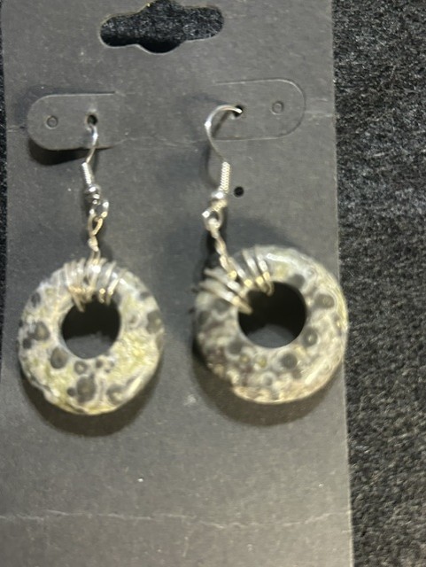Round stone earrings with metal hooks displayed.