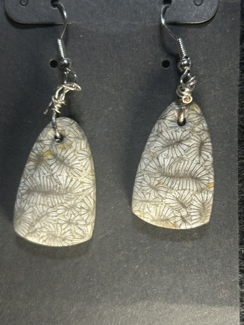 Leaf-patterned stone earrings on display card.