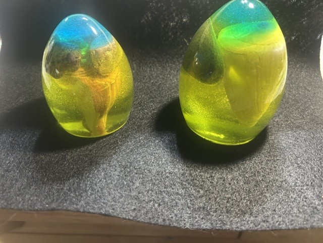 Two colorful glass egg-shaped sculptures displayed.