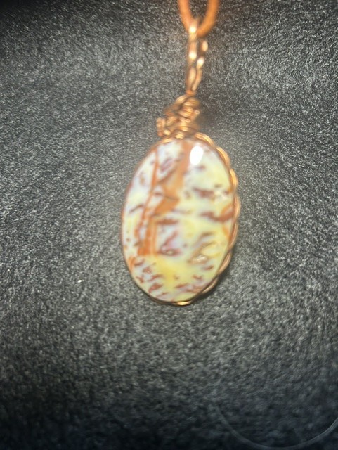 Stone pendant with copper wire wrapping.
