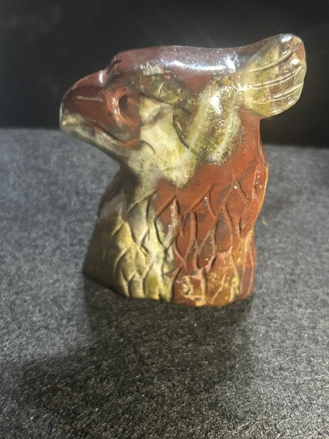 Carved stone figurine of an eagle head.